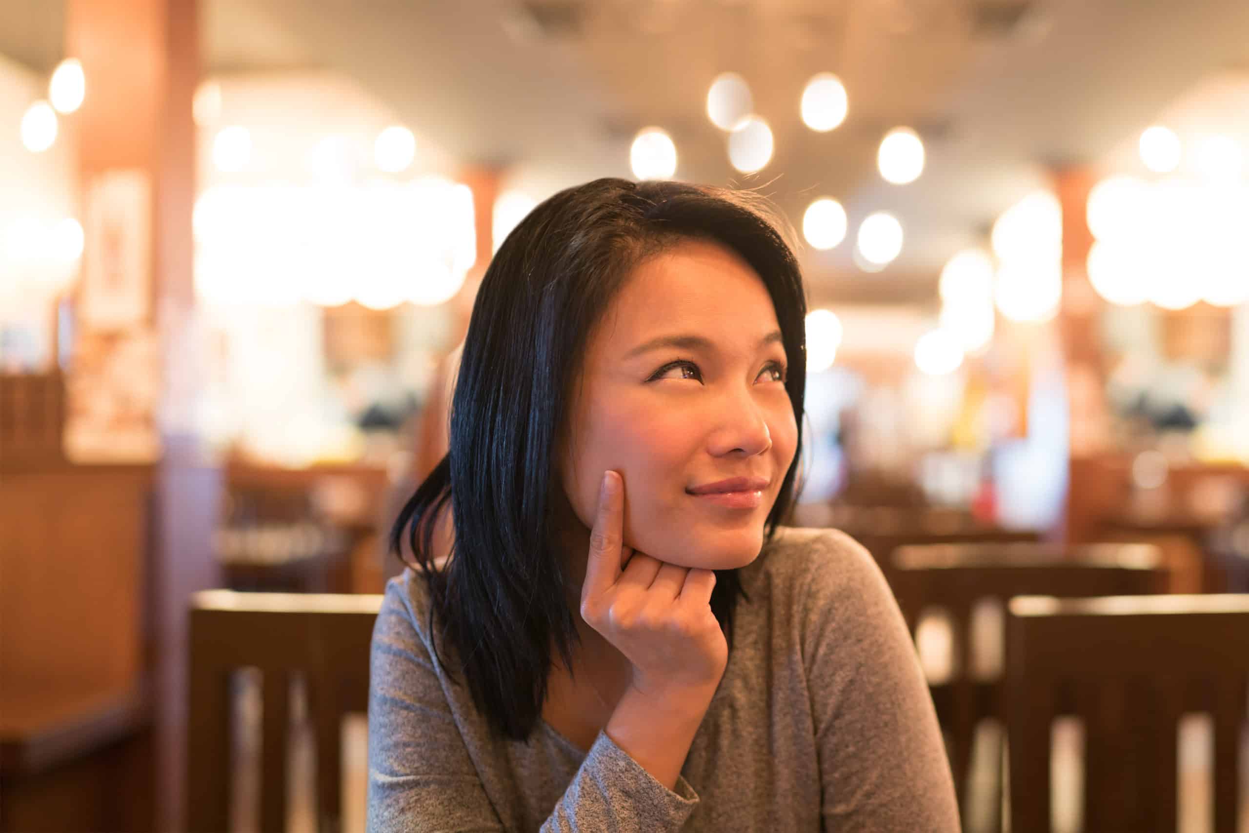 Lady listening and looking up sitting at a restaurant